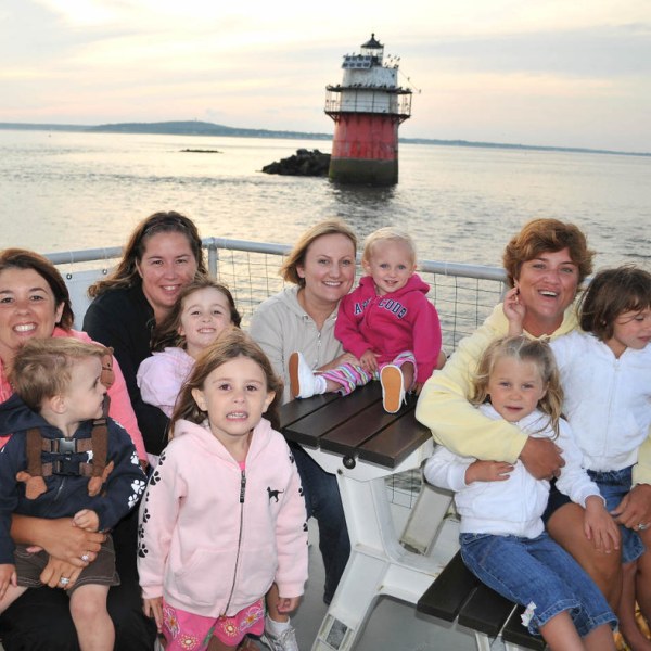 a group of people posing in front of a body of water