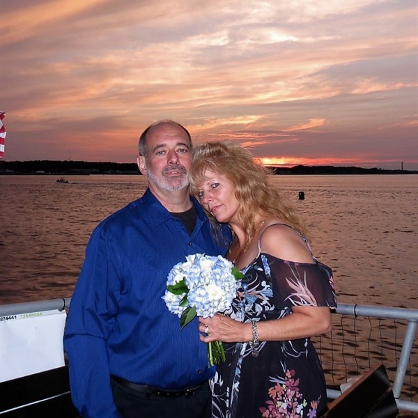 a man and a woman standing in front of a body of water