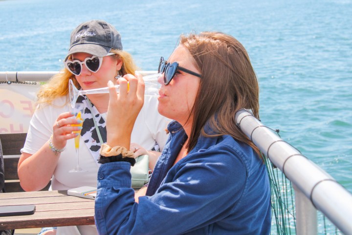 a woman in sunglasses sitting in a boat on a body of water