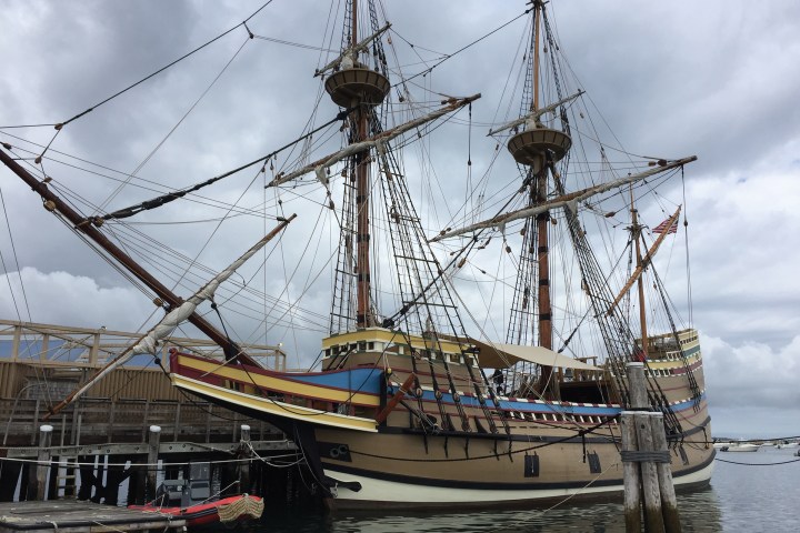 a large ship in the water with HMS Victory in the background