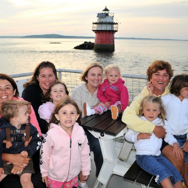 a group of people posing in front of a body of water