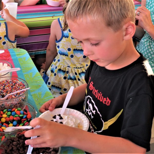 a young boy sitting at a table with a birthday cake