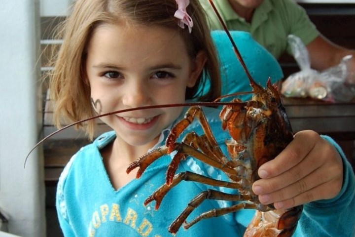 a woman riding on the back of a crab on a table
