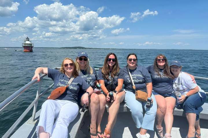 a group of people sitting next to a body of water
