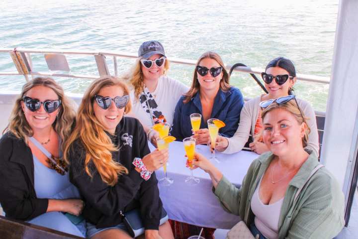 a group of people sitting next to a body of water